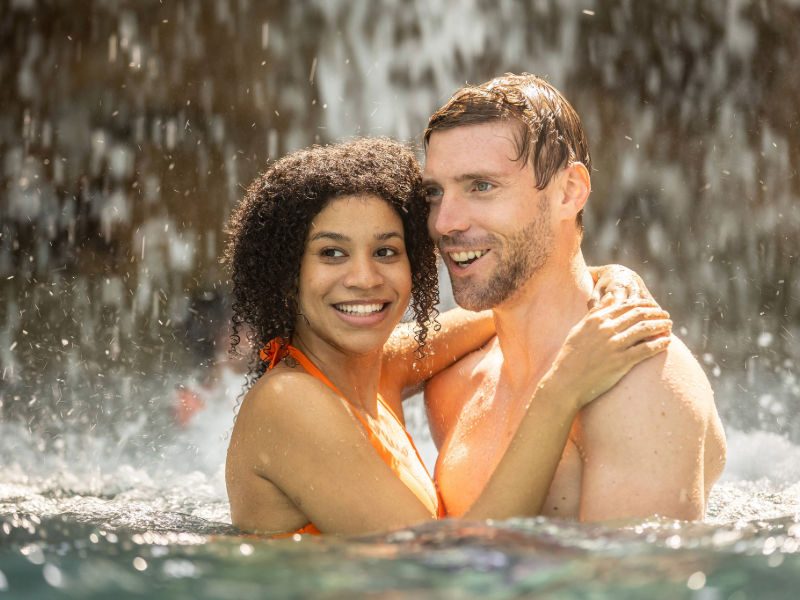 Großer tropischer Badebereich im Tropical Islands mit lagunenförmigem Pool, Palmen, Wasserattraktionen und Liegeflächen unter der lichtdurchfluteten Kuppelhalle.