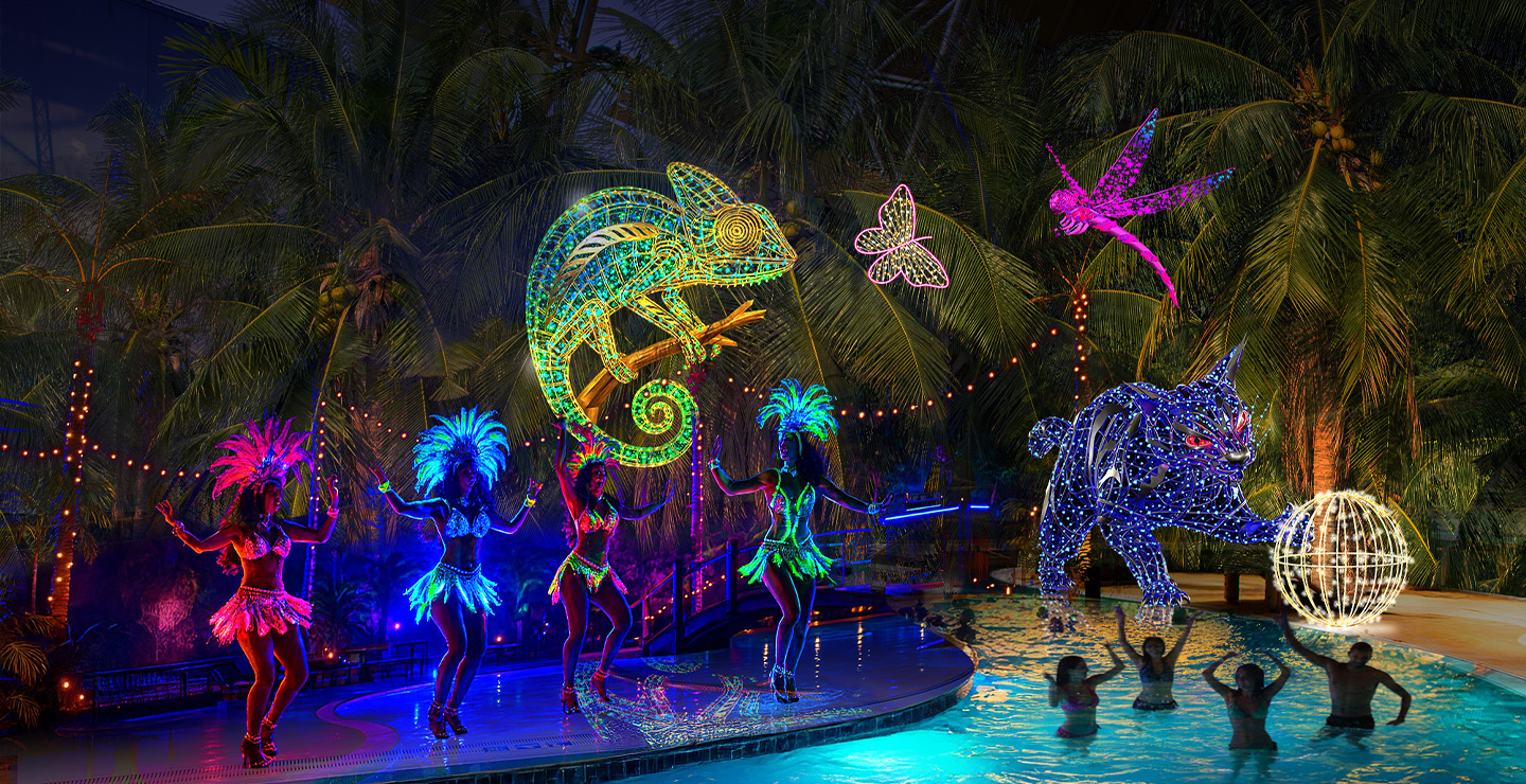 Light event “Glowing Tropics” with samba dancers, light figures, pool, and palm trees.