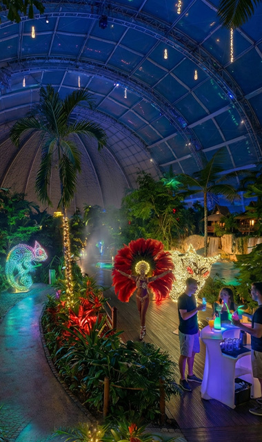 Tropical Islands Dome bei Nacht, beleuchtet durch illuminierte Tierfiguren und Samba-Outfits.