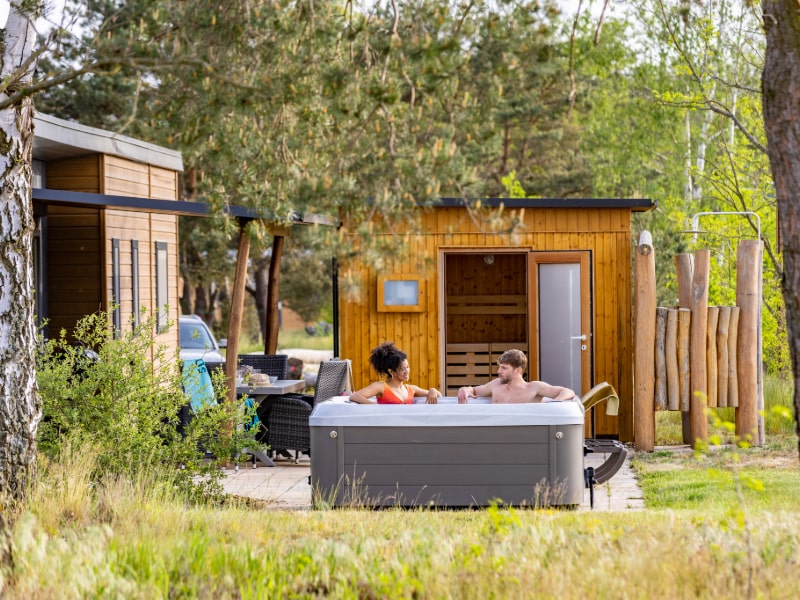Pärchen sitzt im Whirlpool des Sunrise Homes im Tropical Islands