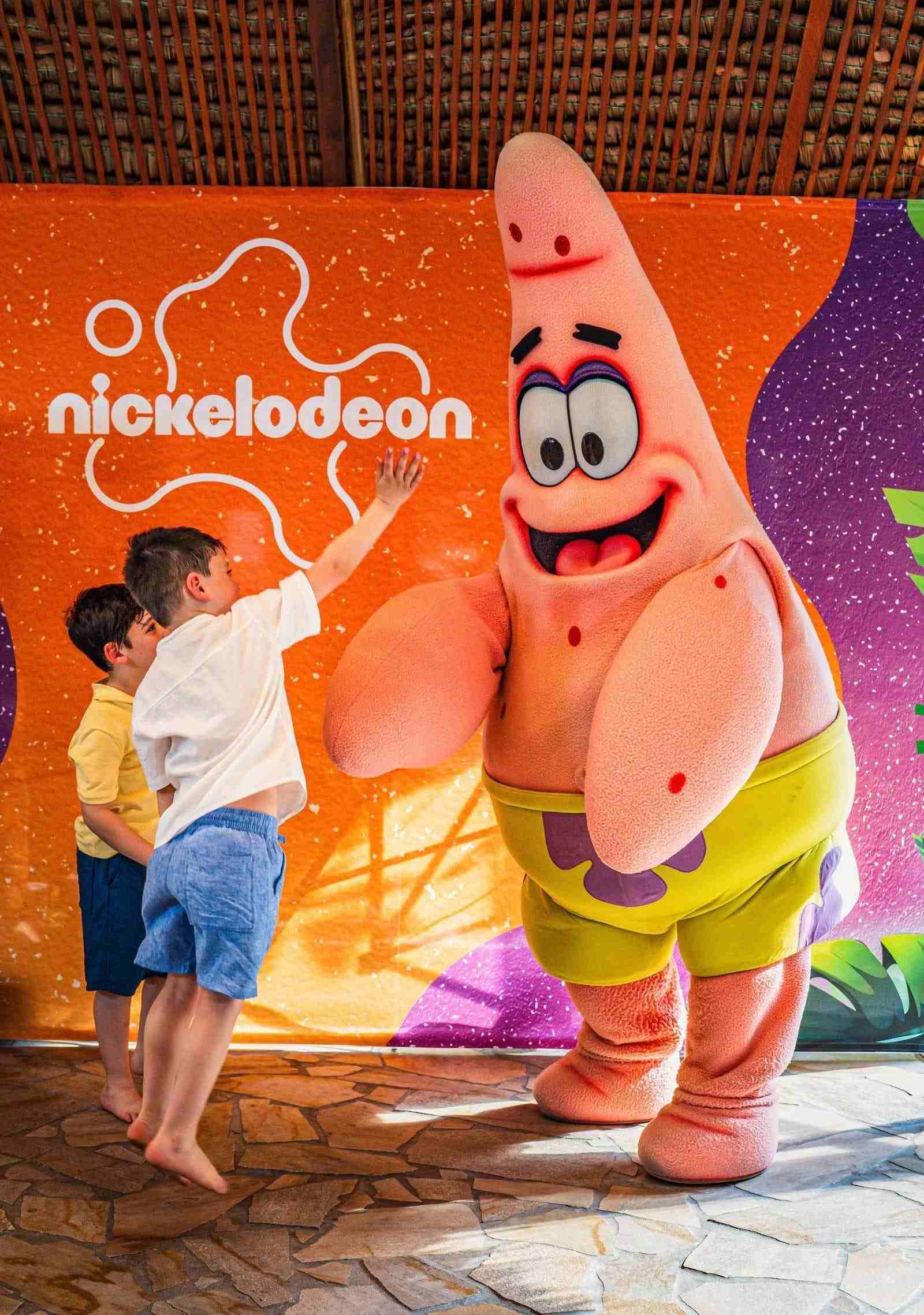 Zwei Kinder springen und interagieren mit Patrick von Nickelodeon