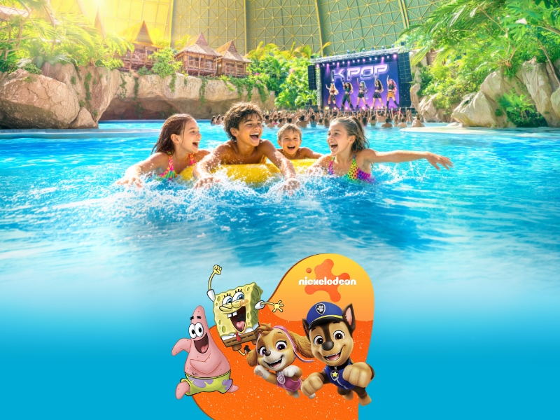 Vier Kinder im Pool der Lagune, im Hintergrund eine Bühne mit einer K-Pop Show, im Vordergrund die Nickelodeon Freunde SpongeBob, Patrick, Chase und Skye auf orangem Hintergund.