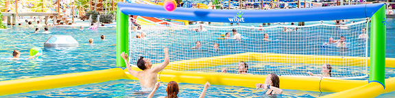 Menschen spielen Wasser-Volleyball in einem Pool mit gelber Umrandung und grün-blauem Netz
