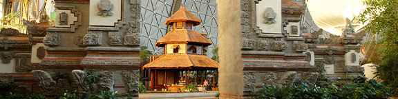 Traditionelles Bali-Tor mit einem asiatischen Pavillon im Hintergrund.