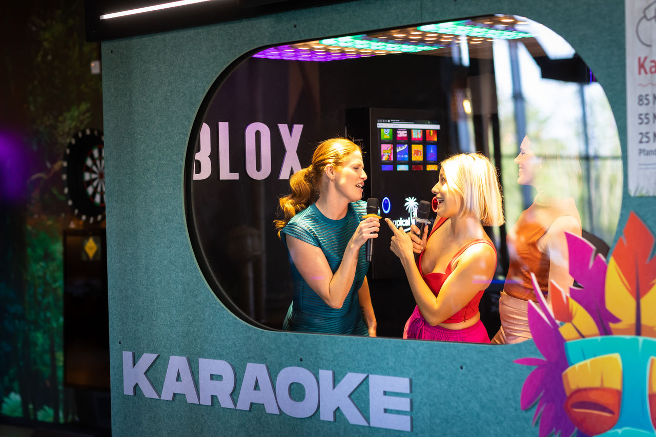 Zwei Personen singen in einer Karaokebox.
