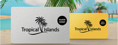  Zwei Tropical Islands Jahreskarten am Sandstrand—eine silberne Platin-Karte, eine goldene Gold-Karte.