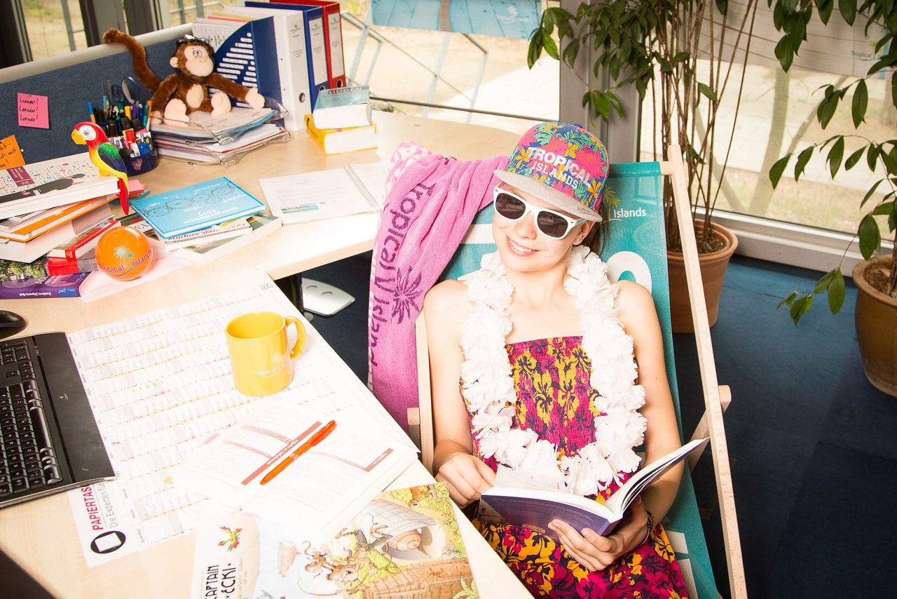Lächelnde Frau mit Tropical Islands Merch im Liegestuhl