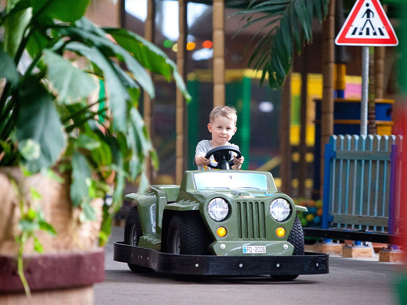 Kind fährt mit Mini-Car im Kinderclub
