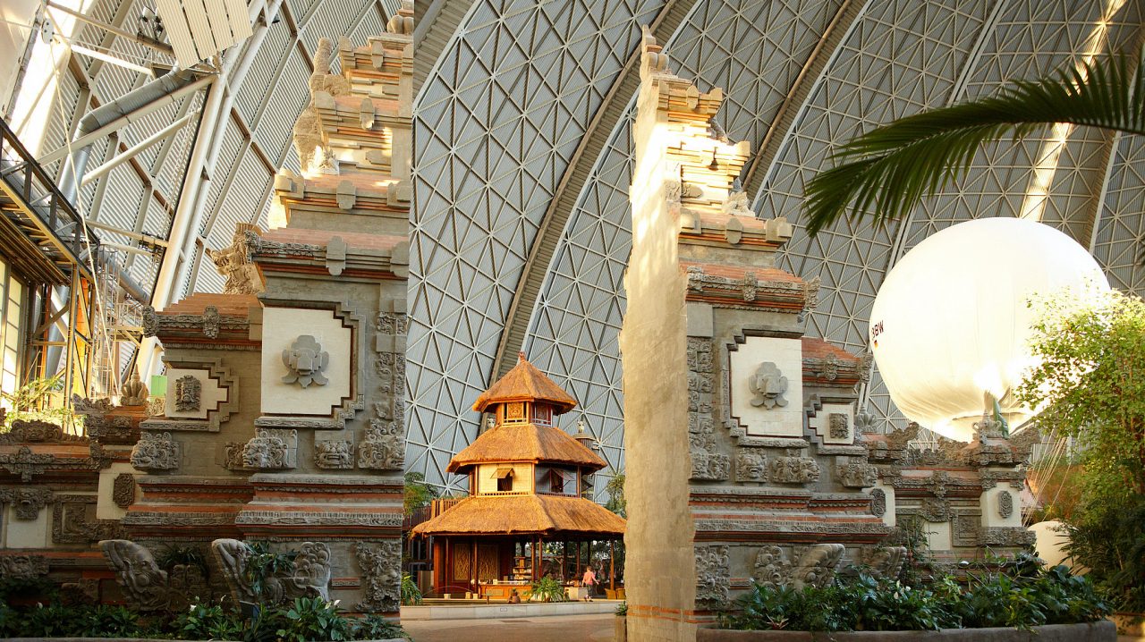 Traditionelles Bali-Tor mit einem asiatischen Pavillon im Hintergrund.