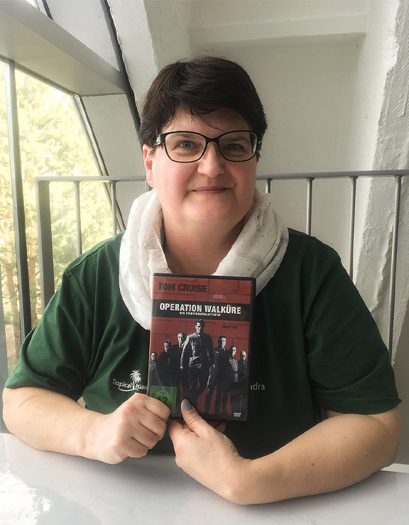 Person hält eine DVD-Hülle des Films Operation Walküre an einem Tisch.