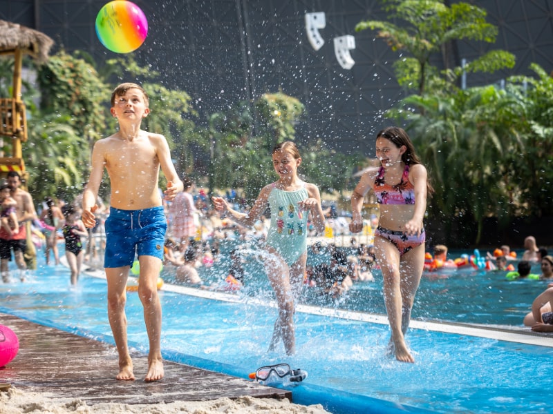 Indoor-Pool Lagune mit tropischer Vegetation und den Waterfall Suites unter einer Kuppel.