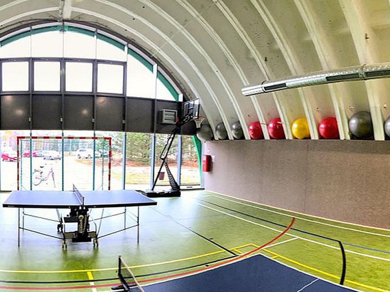 Freizeitcenter mit Tischtennisplatte, Basketballkorb und bunten Gymnastikbällen.