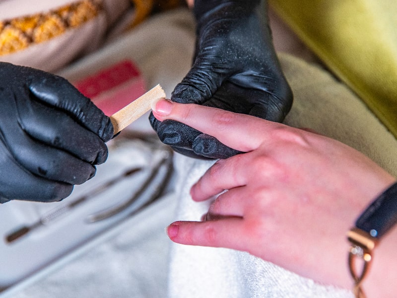 One person files the fingernails of another during a manicure.