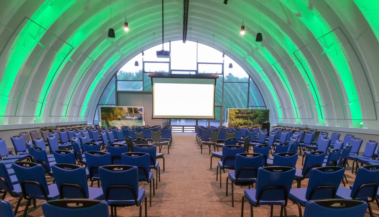 Congress Center with a large number of chairs and a white screen in the middle.
