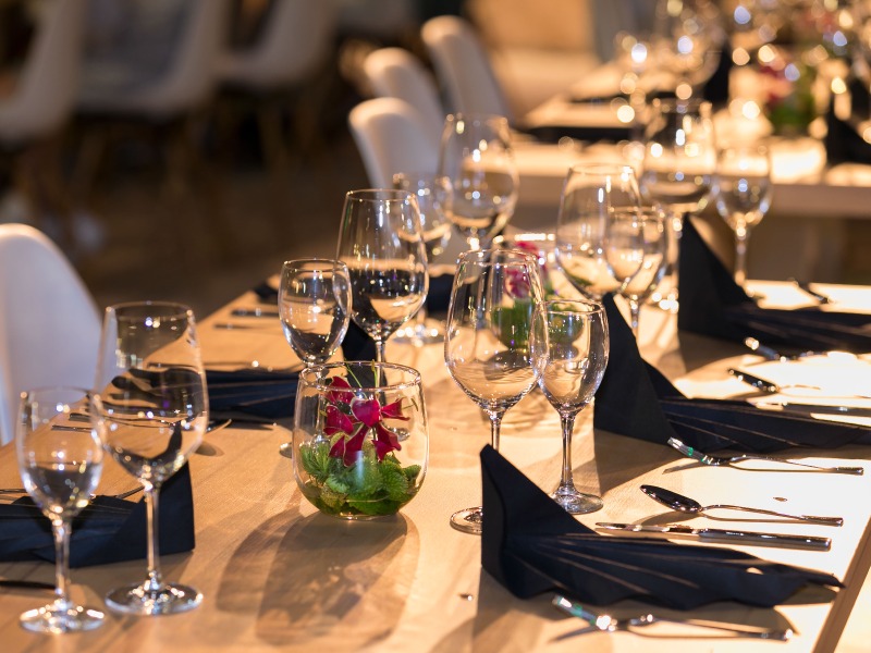 Table set with folded gray napkins, menu, and wine glasses.