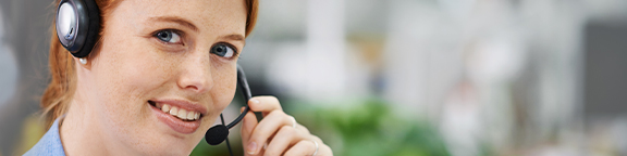 A person is wearing a headset in an office, with green elements in the background.