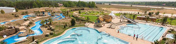 AMAZONIA outdoor area with spacious pools, water slides, sunbathing areas and green surroundings in sunny weather.