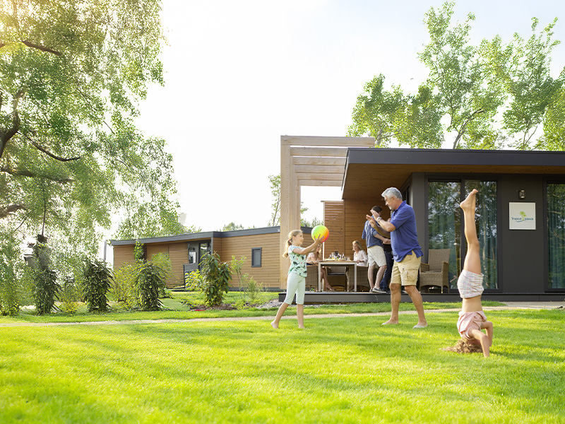 Family playing on the green area in the vacation home park