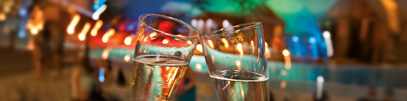 Two champagne glasses clinking, atmospheric lighting in the background