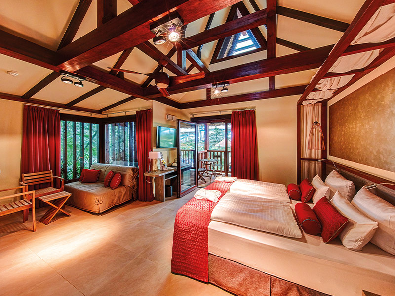 Cosy suite with bed, seating area and open balcony door in the background