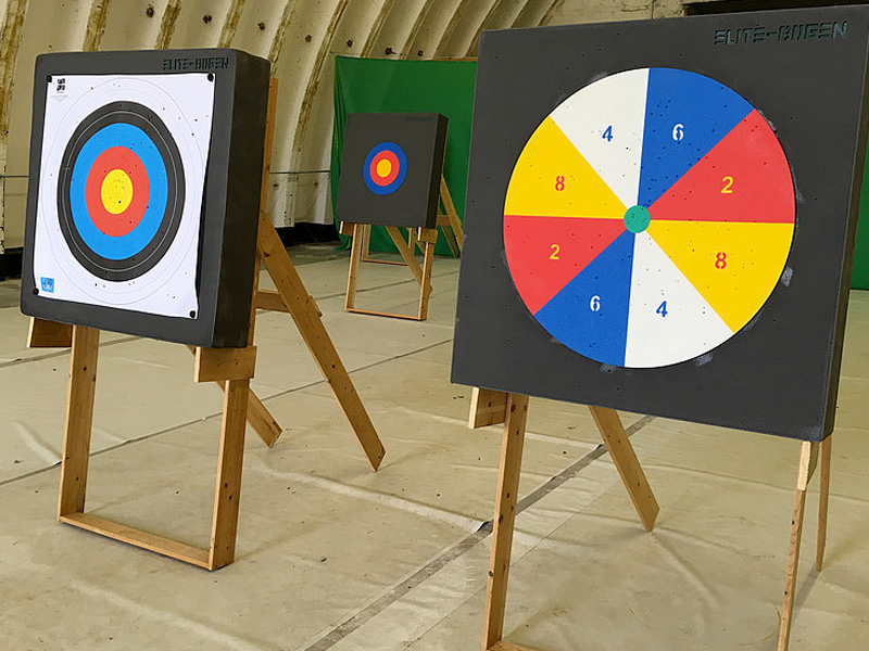 Three archery targets in a hall, with colored rings and number markings.